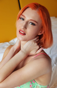 Lola Red teases alone on white sheets, fingers sliding slow through her wetness in lace lingerie