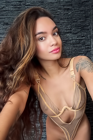 Dulce Unveils Her Tattooed Flesh, Sheer Gold Lingers Against Wall